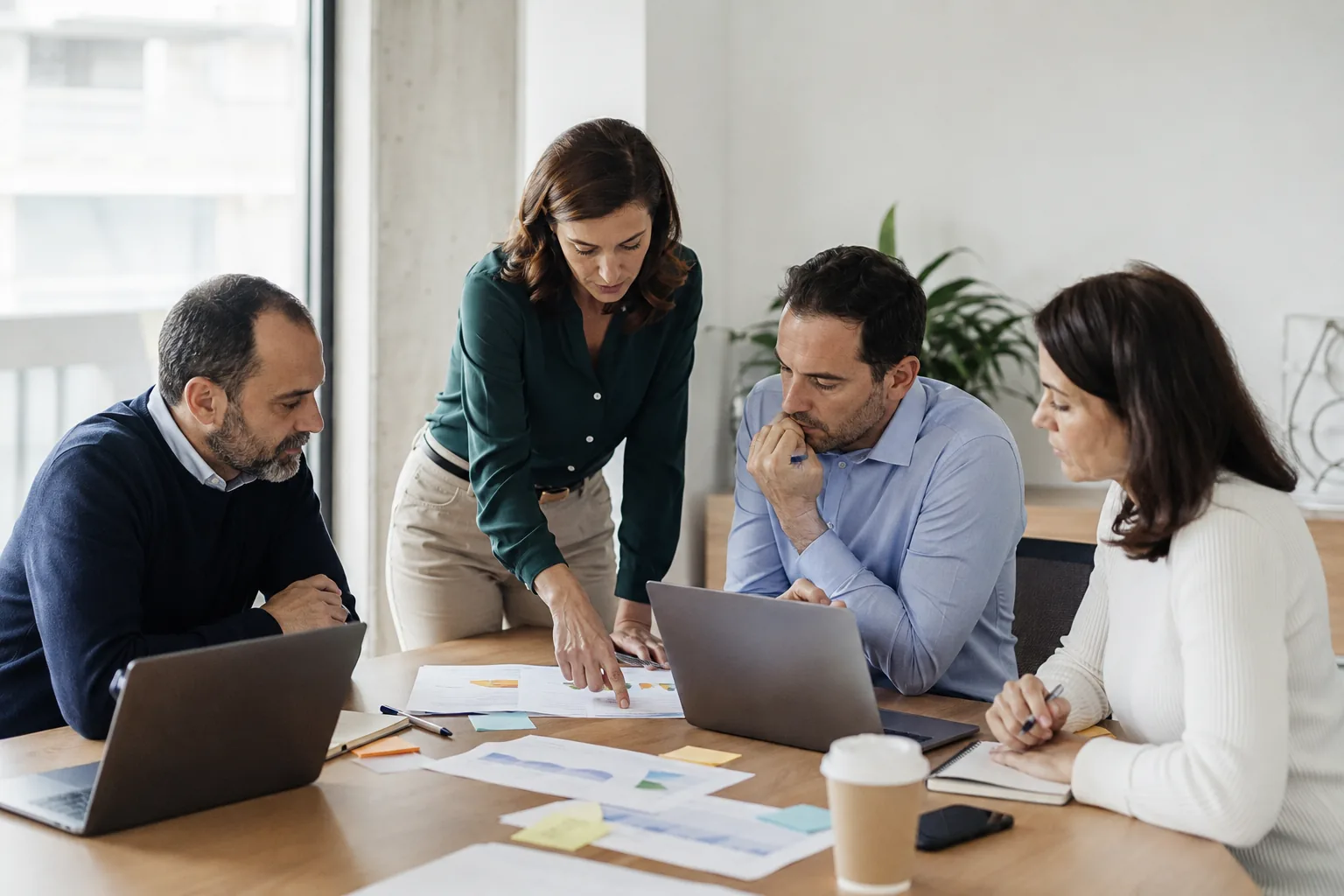 Equipo de distintos departamentos analizando documentación y una solución a medida en una oficina